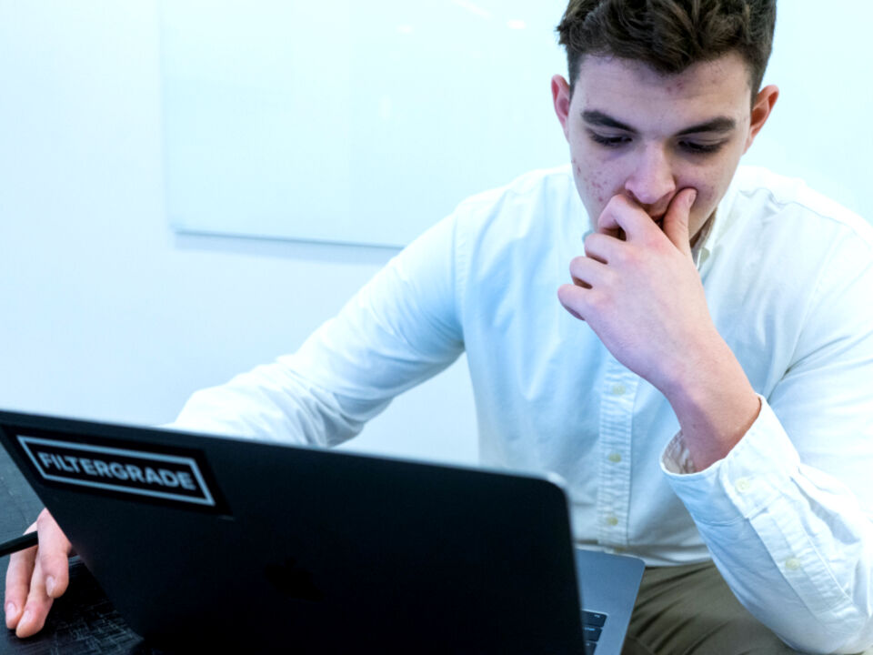 A developer thinking over a problem at a laptop