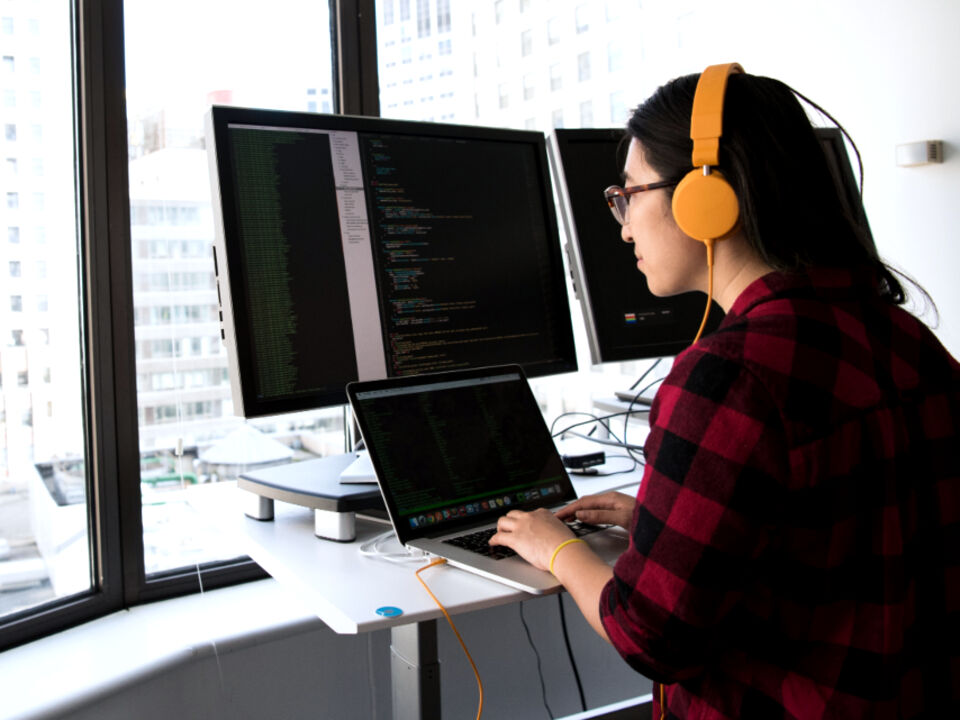 A developer working at two monitors
